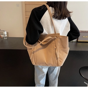 Dettaglio della borsa tote in velluto a coste kaki con tasca laterale e accenti in corda