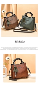 Detailed view of pebbled leather texture, gold Danbaoly logo, and cute doll charm on handbag