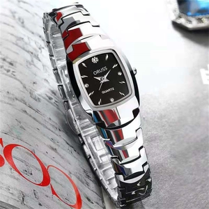 Macro view of black tonneau quartz watch face with crystal markers on silver steel band