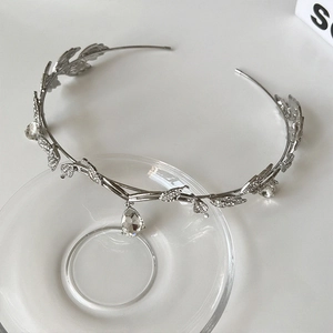 Close-up of silver crystal bridal crown with leaf motifs and water drop pendant