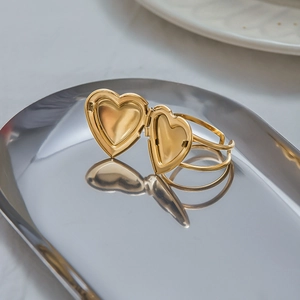 Anello con medaglione a cuore in acciaio inossidabile dorato su vassoio in argento lucido