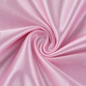 Gros plan du tissu en satin rose montrant une texture soyeuse et un drapé plissé élégant