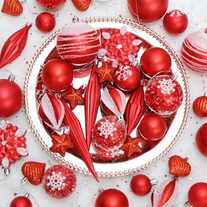 Red Christmas tree ornaments set with snowflakes and glitter patterns in silver tray