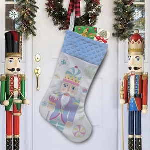 Blue and white Christmas stocking with nutcracker soldier pattern hanging on a festive door
