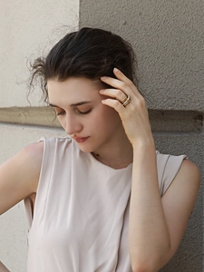 Close-up of triple layered 18K gold plated rings with pearls on a female model hand