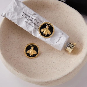 Vue détaillée des boucles d'oreilles abeille plaquées or 18 carats avec émail noir