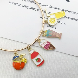 Detail of a gold bracelet with five enamel charms like ice cream and fruit drinks