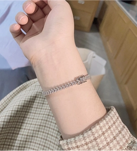 Close-up of a silver moissanite tennis bracelet with pavé setting on a woman's wrist