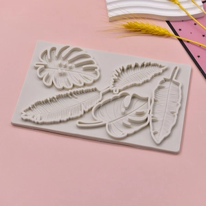 Gray silicone fondant mold featuring monstera and maple leaf patterns for cake decorating