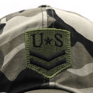 Close-up of military embroidery on green camouflage tactical baseball hat