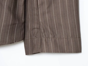 Gros plan détaillé du tissu marron foncé à rayures montrant les coutures et la texture