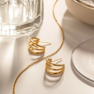Detail view of 18K gold plated multi-layer hoop earrings with high-shine polished finish