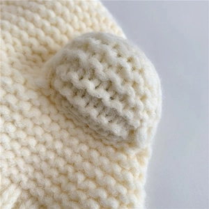 Detailed close-up of cream knit baby hat with soft 3D bear ears and thick yarn texture