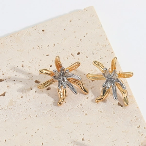 Macro shot of two-tone irregular floral earrings with polished gold and silver finish