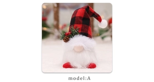 Detail of Christmas gnome with red plaid hat, pine cone accent and warm glowing lights