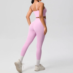 Close-up of pink high-waist yoga leggings and strappy sports bra with smooth fabric texture