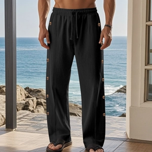 Detail of men's black linen pants showing drawstring waist and side button accents