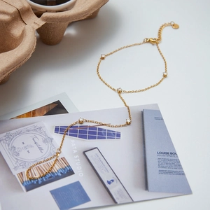 Detail of 18K gold stainless steel hand chain with Five sparkling cubic zirconia stones