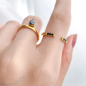 Gold-plated ring set with pear-cut black zircon and minimalist open band on finger