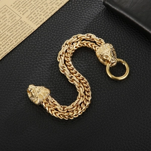 Detailed close-up of a gold lion head braided stainless steel chain bracelet on leather