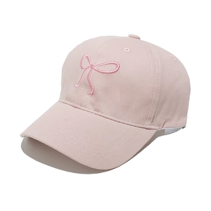 Detailed macro view of embroidered pink bow on cotton baseball cap for women
