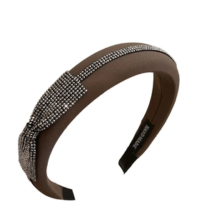 Brown padded rhinestone headband with crystal leaf motifs and handmade label tag
