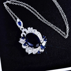Macro view of sapphire pendant with blue gemstones on dark textured background