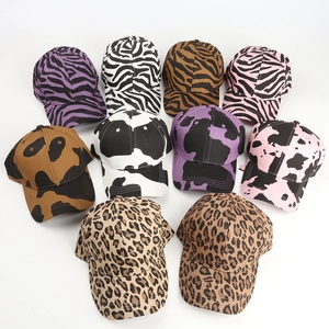 Detailed close-up showing variety of animal print patterns on cotton baseball caps