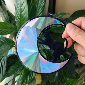 Holographic black cat crescent moon suncatcher casting rainbow prism light reflections