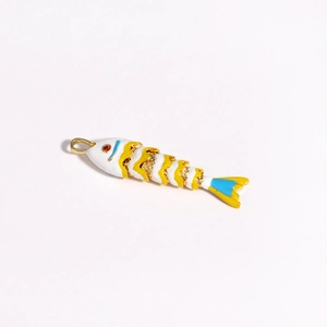 Vue macro d'un pendentif carpe koï articulé en émail avec motifs blanc et jaune et dorure