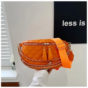 Detail of orange quilted waist bag with metal chain and wide fabric shoulder strap