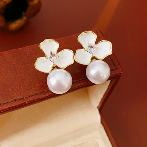 Detail of flower earring with white enamel petals, square crystal, and a large hanging pearl