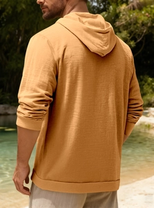 Detail view of the back of a ginger cotton linen hoodie with rich fabric texture and hood