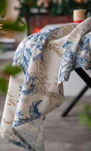 Detail of pine branch print on rustic cotton linen tablecloth with elegant drape