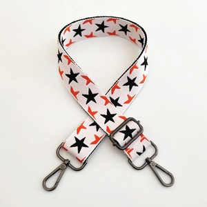 Close-up of adjustable wide shoulder strap with black stars and gunmetal swivel hooks