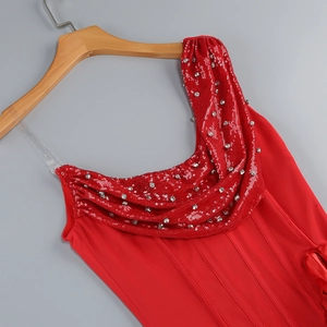 Close-up of red sequined dress shoulder detailing with silver embellishments on a hanger
