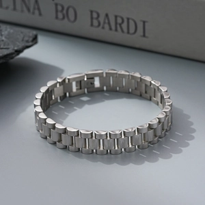 Macro detail of the silver metal watch band style bracelet on a minimalist background
