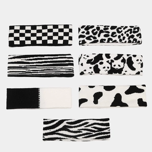 Set of seven black and white knitted sports headbands with various animal and geometric prints