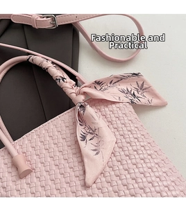 Detailed view of pink woven leather handbag with floral silk scarf wrapped around handle