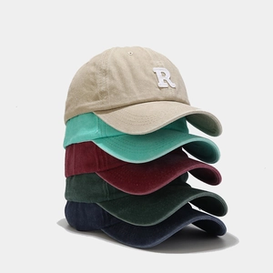 Stacked washed vintage baseball caps with embroidered R logo in five diverse colors