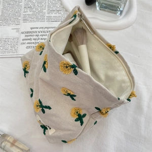 Détail de la trousse en toile avec broderie de tournesol, fermeture éclair et rangement