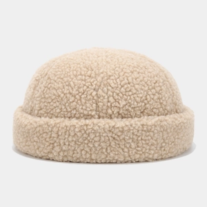 Close-up of thick beige teddy fleece fabric texture on a docker cap brim