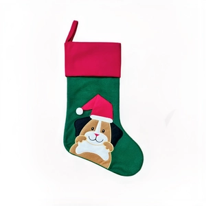 Détail d'une chaussette de Noël en lin vert avec broderie de chien et boucle rouge