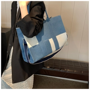 Detail of color-block denim tote bag showing spacious capacity and dual strap design