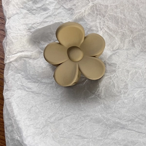Detail view of flower shark clip in matte beige finish with textured surface