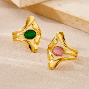 Macro detail of 18K gold-plated rings with oval green and pink cat-eye gemstones