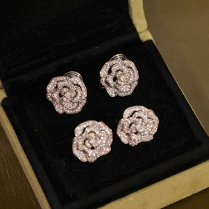 Élégantes boucles d'oreilles camélia argentées avec cristaux dans un écrin en velours noir