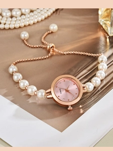 Dettaglio orologio al quarzo oro rosa con cinturino di perle, quadrante rosa e strass