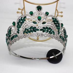 Detailed close-up of emerald green leaf gemstones on a silver baroque bridal crown