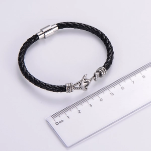 Detail view of a 21cm black braided leather men's anchor bracelet with a ruler for scale